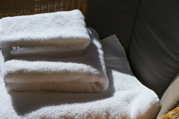 Stack of clean white towels on a surface.